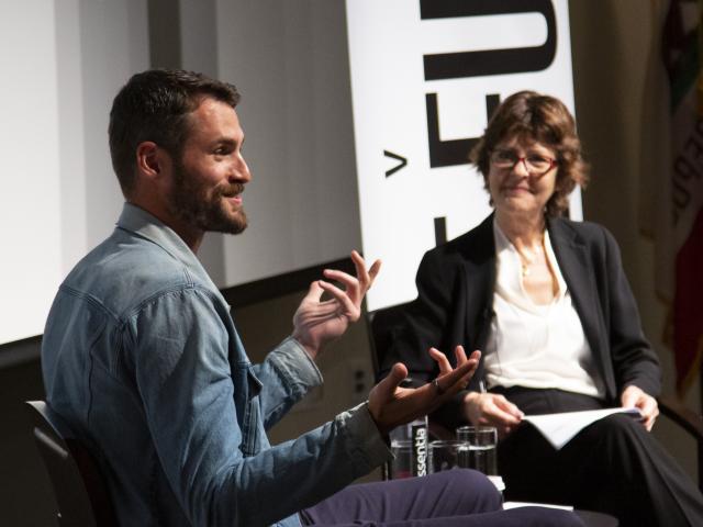 Kevin Love and Michelle Craske speak at a panel stage.