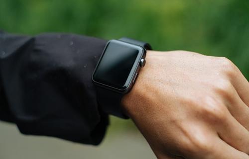 A hand wearing an Apple watch, screen off.