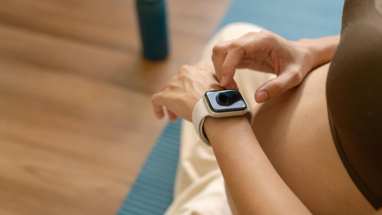 A pregnant woman taps an Apple Watch