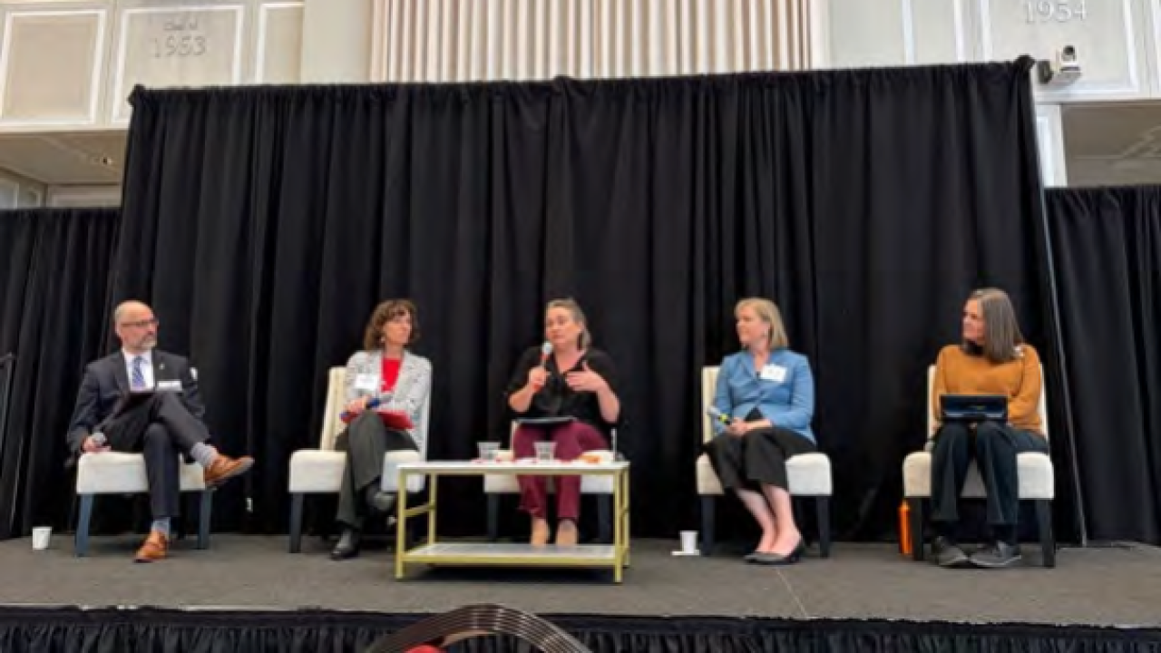Eric Chapman, Rebekah Hersch, Michelle Popowitz, Megan Barnett, and Cinda Christian sit on an on-stage panel.