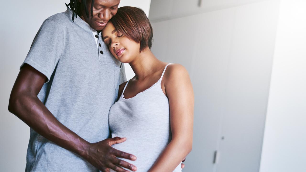 A father and pregnant mom embrace.