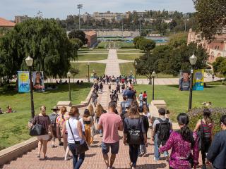A throng of students walk down an outdoor staircase.